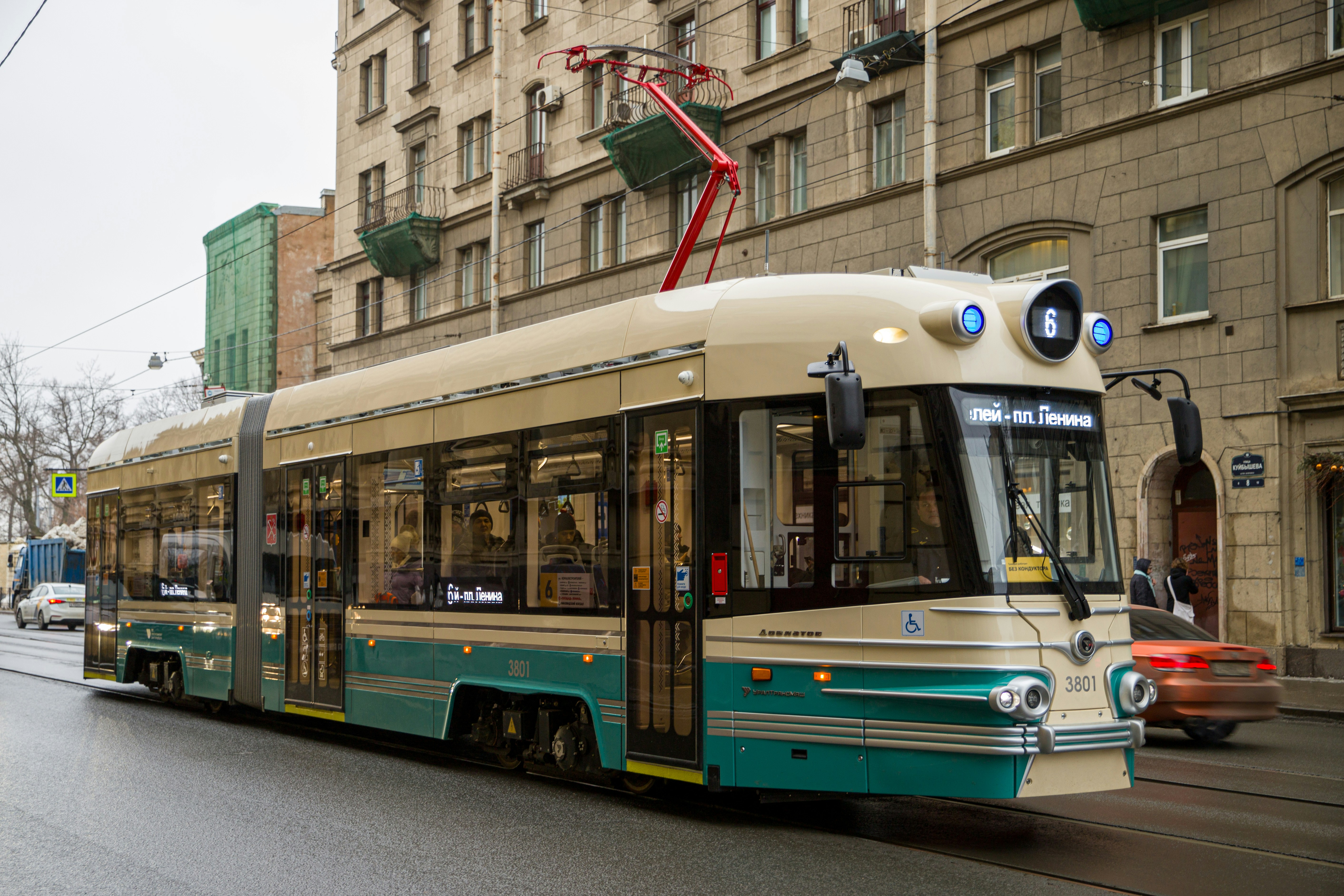 a green and white trolley on a city street