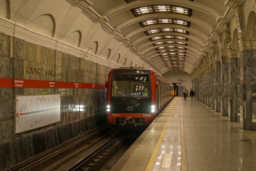 a red train pulling into a train station