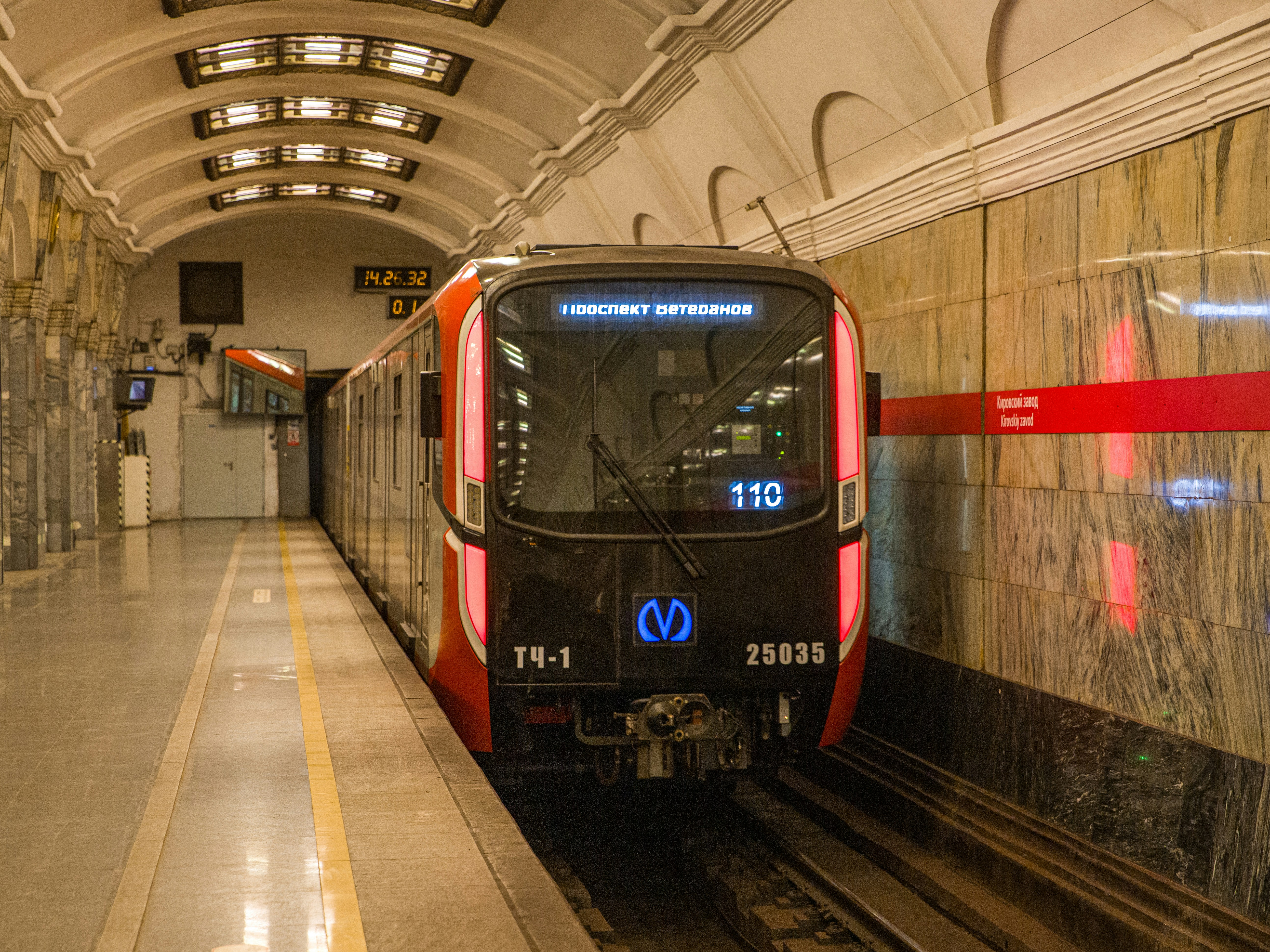 a red and black train pulling into a train station
