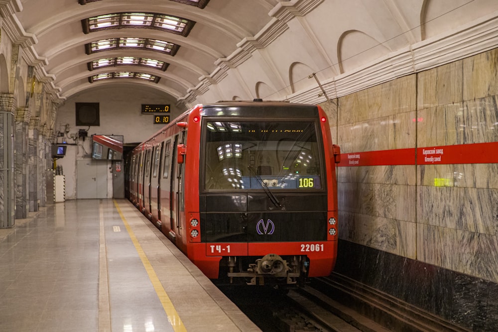 a red train pulling into a train station