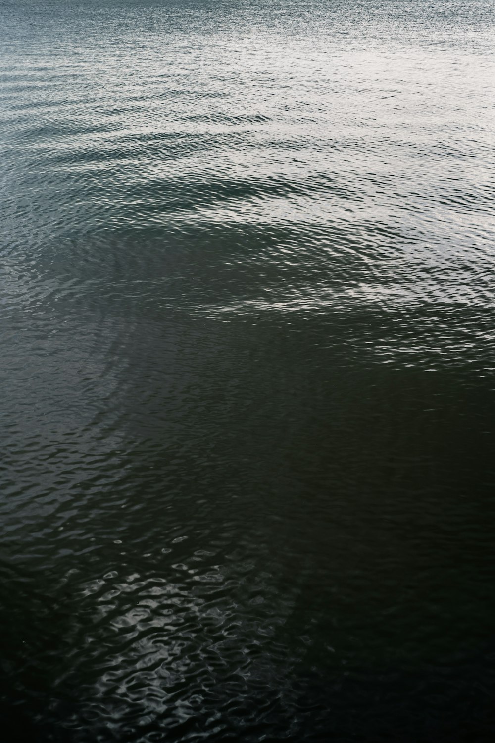 a large body of water with a boat in the distance