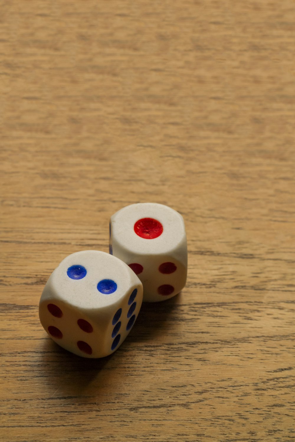 two dices sitting on top of a wooden table