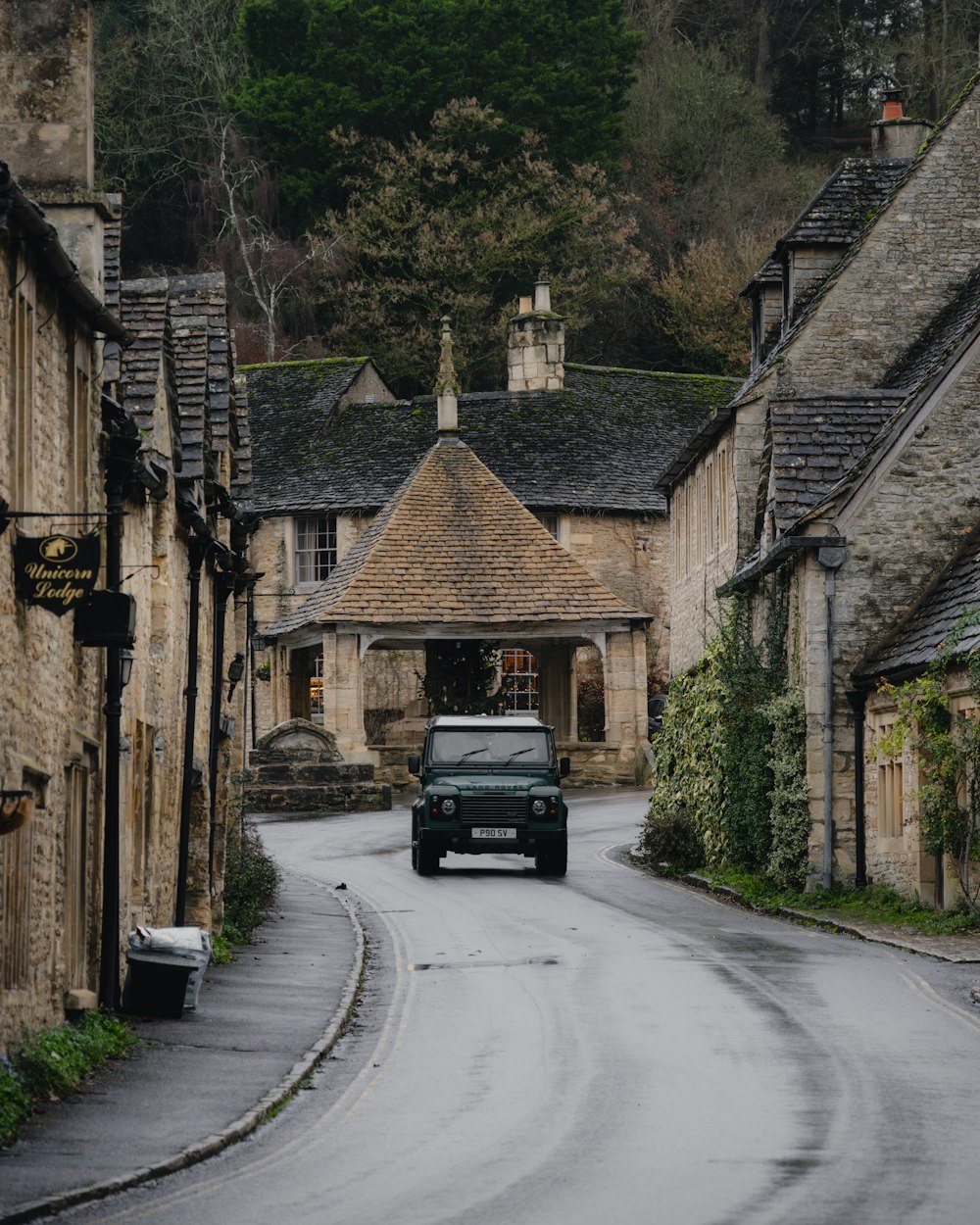 a car driving down a street next to a stone building