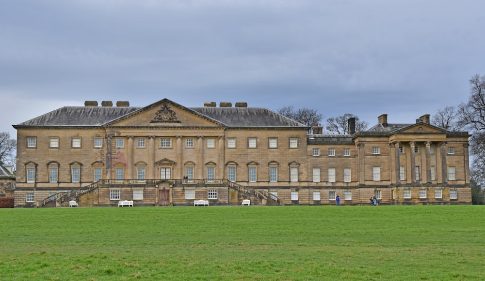 a large building with a grassy field in front of it