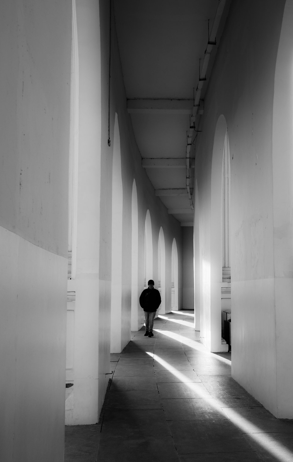 a man is walking down a long hallway