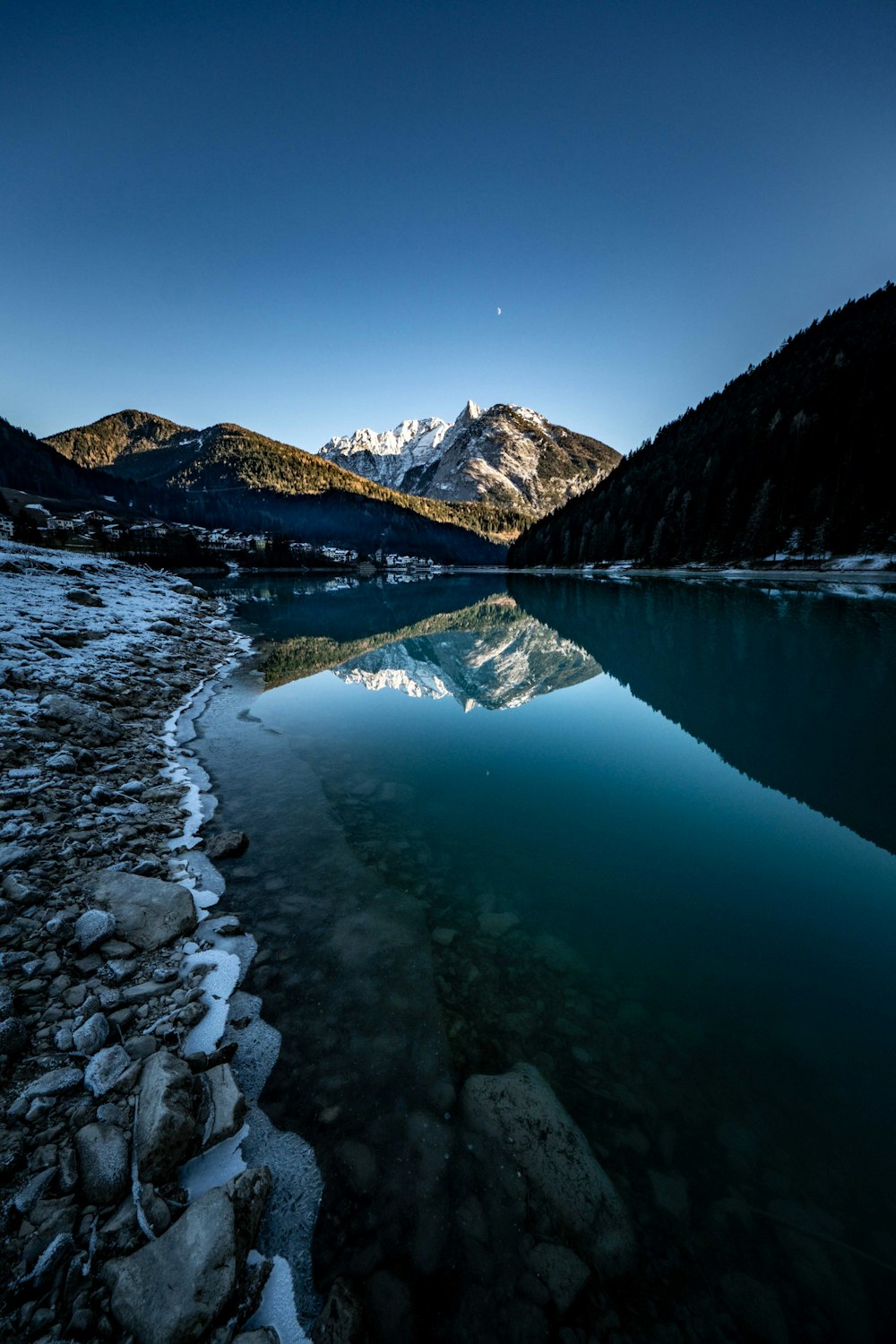 a body of water surrounded by snow covered mountains