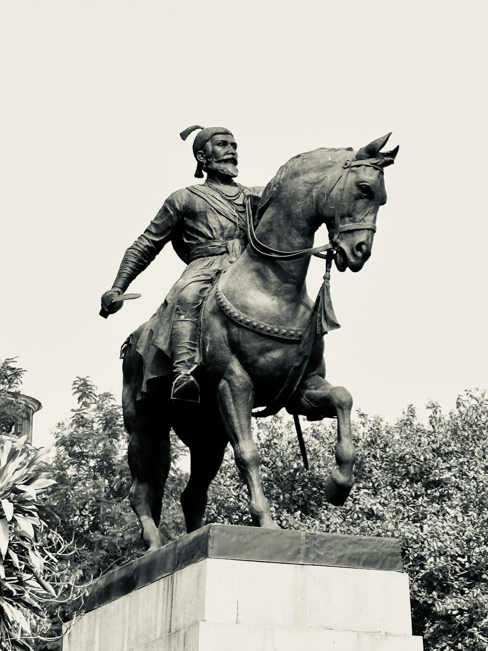 uma foto em preto e branco de uma estátua de um homem em um cavalo