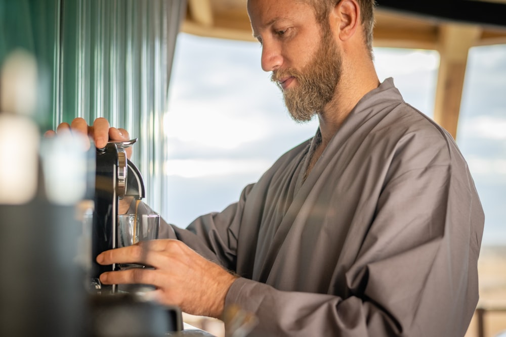 a man standing next to a window holding a glass