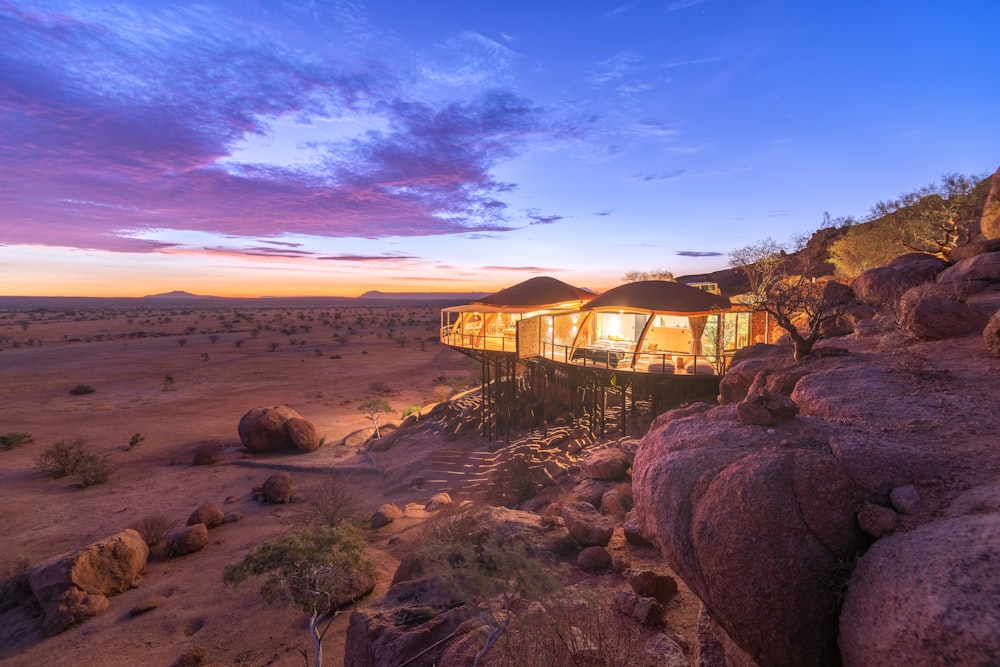 a tent in the middle of a desert at sunset