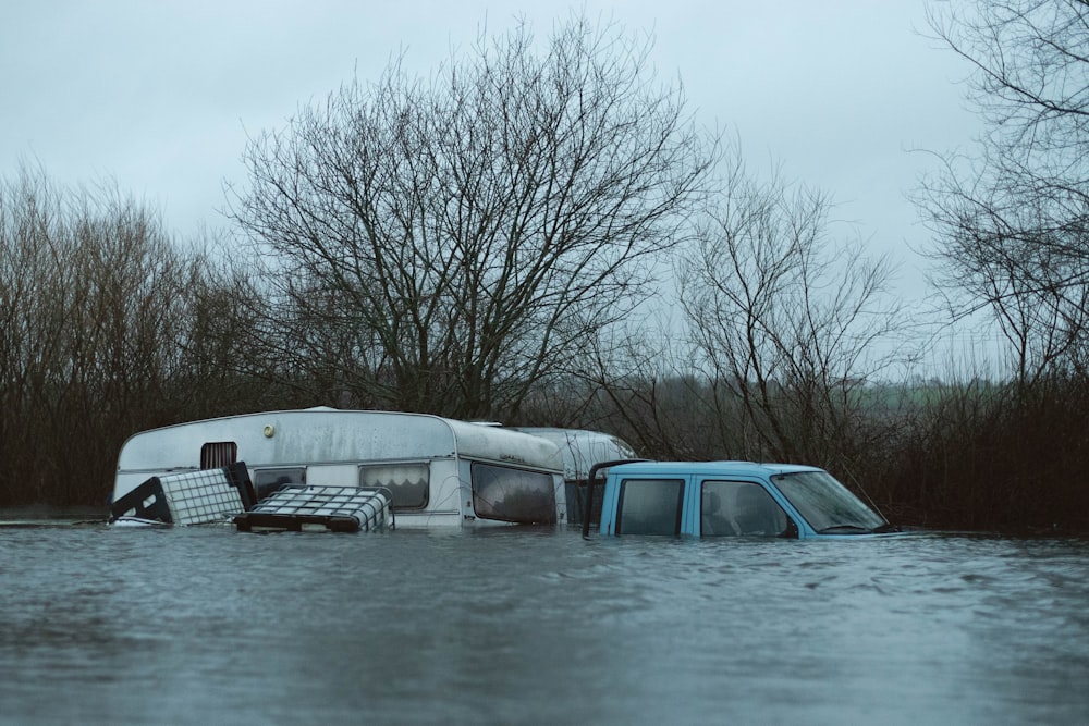 a van is in a flooded area with trees in the background