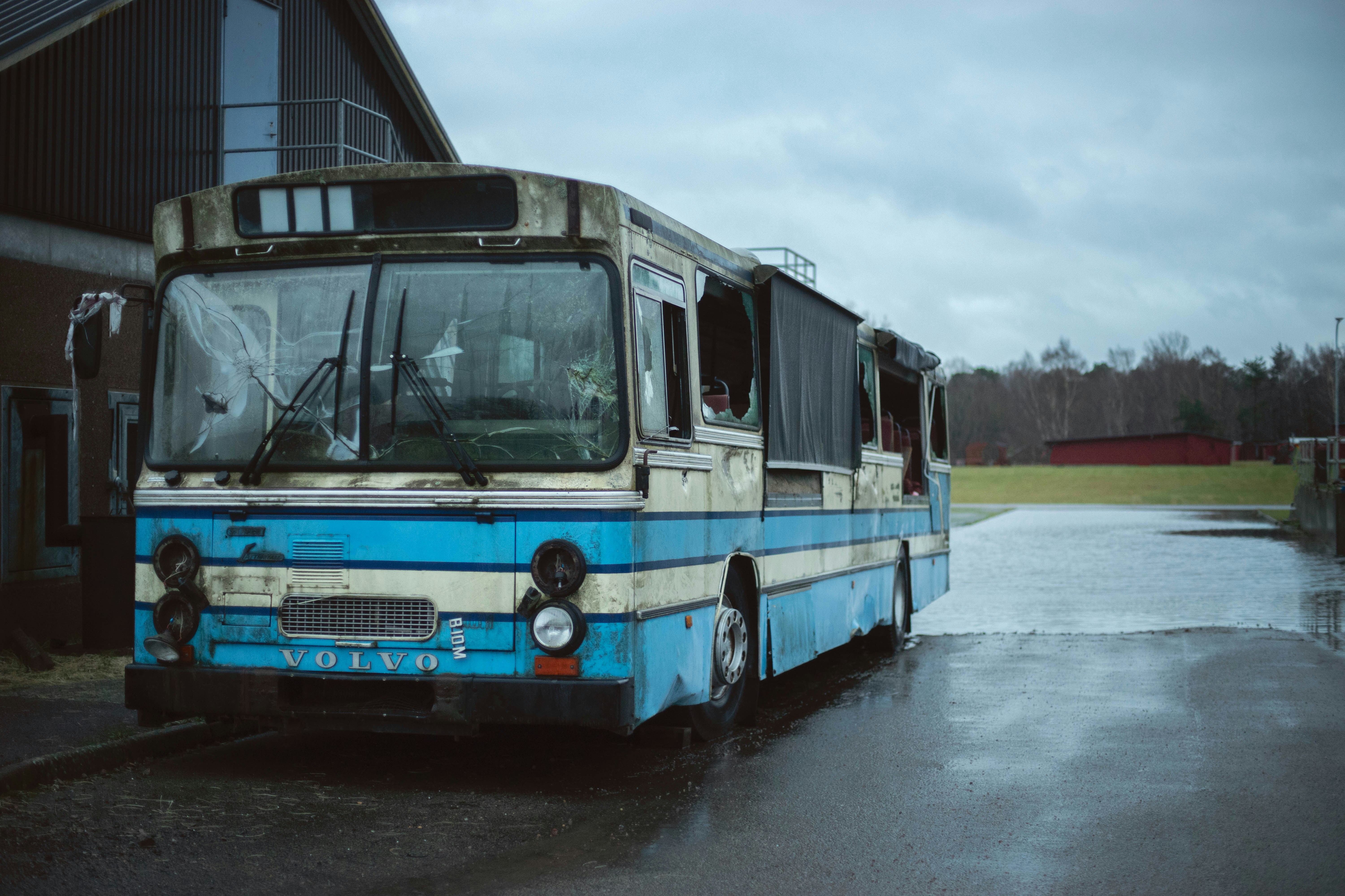 a blue and white bus parked in front of a building