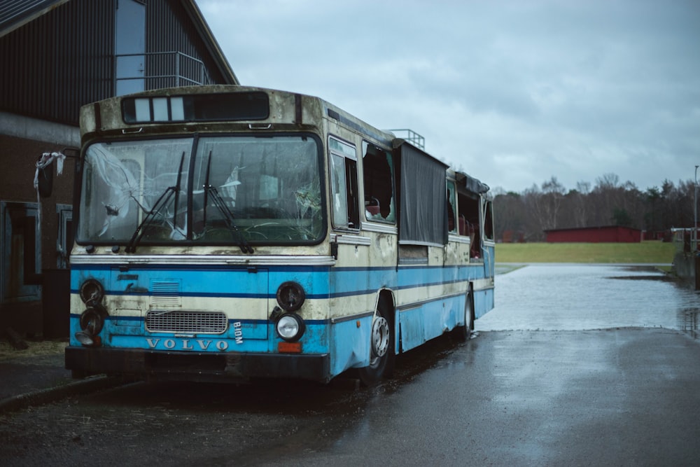 a blue and white bus parked in front of a building