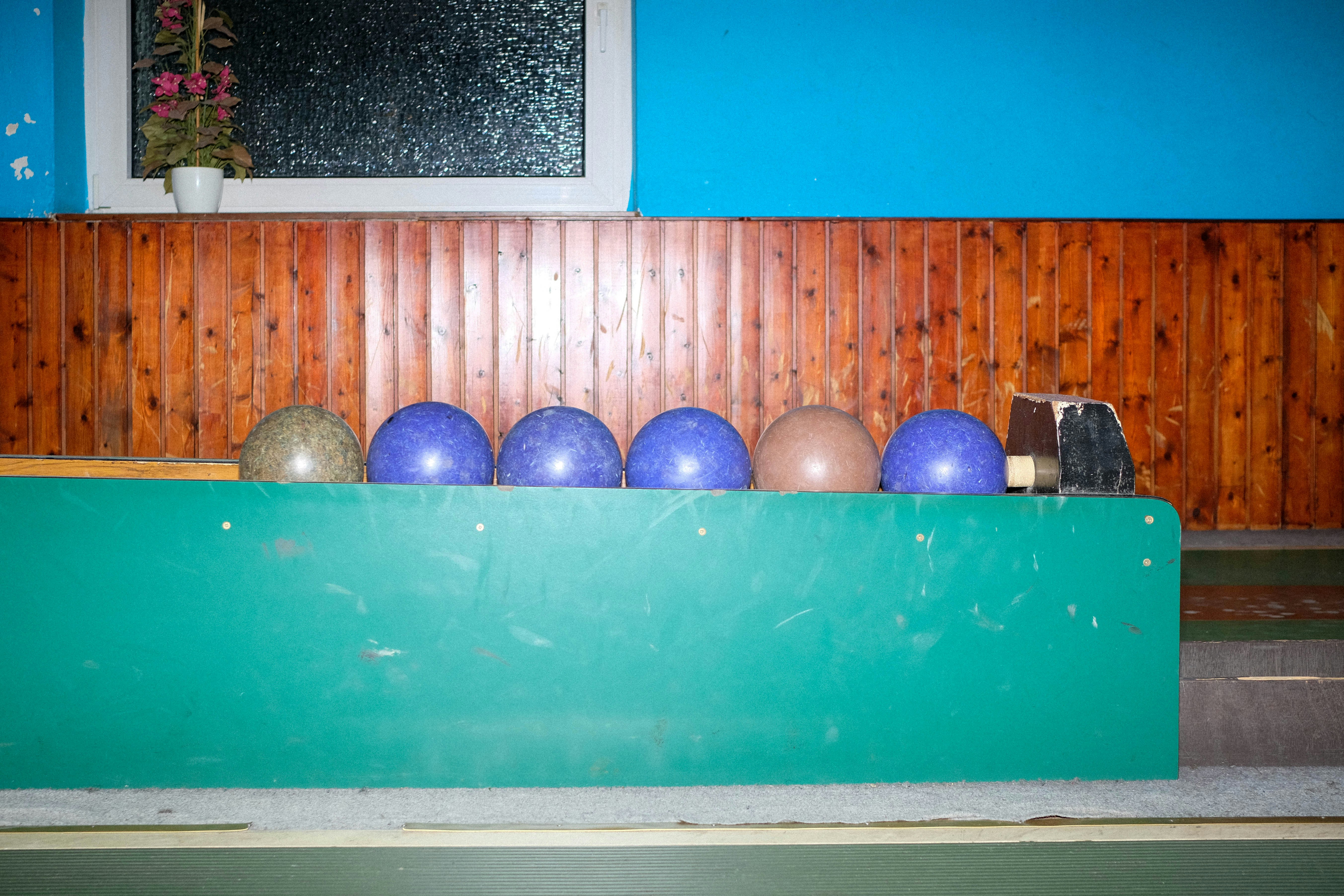 a green shelf with balls and a potted plant