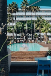 a hotel with a pool surrounded by palm trees