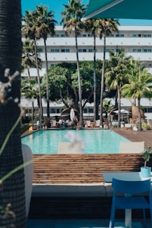 a hotel with a pool surrounded by palm trees