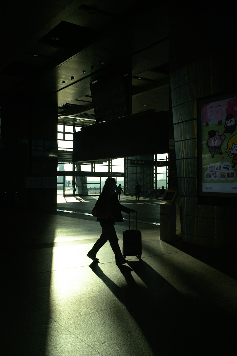 a person walking with a suitcase in a dark room