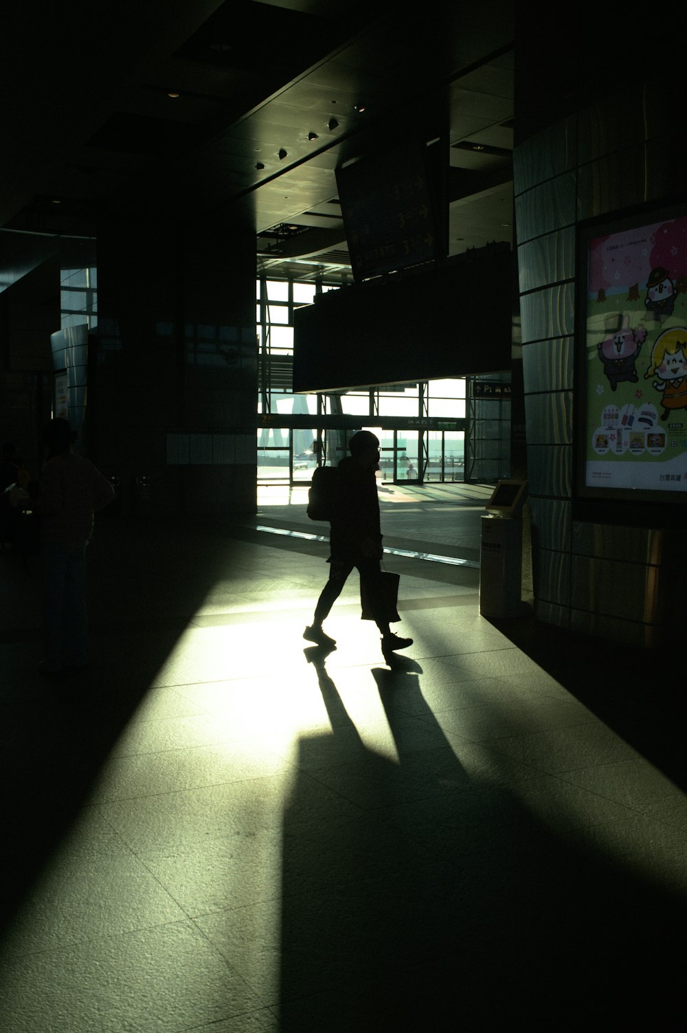 a person walking in a dark room with a television