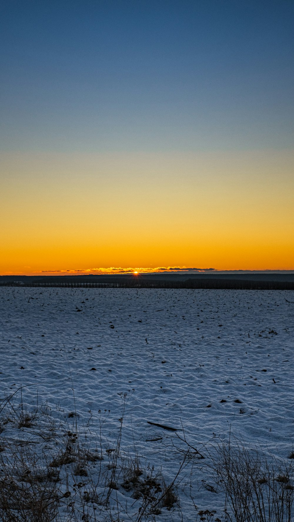 a large body of water with a sunset in the background