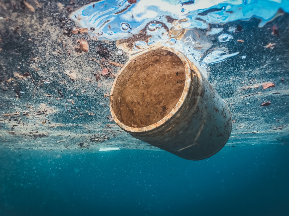 Un barril flotando en el agua cerca del fondo del océano