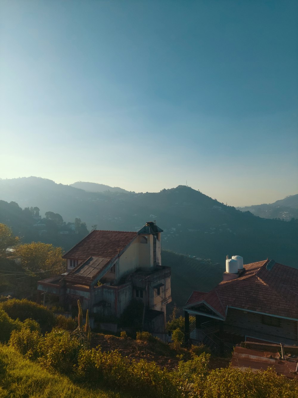 a house on a hill with mountains in the background