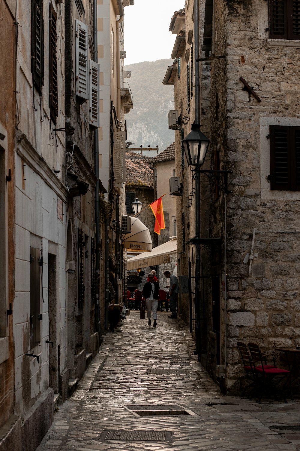 a narrow street with people walking down it