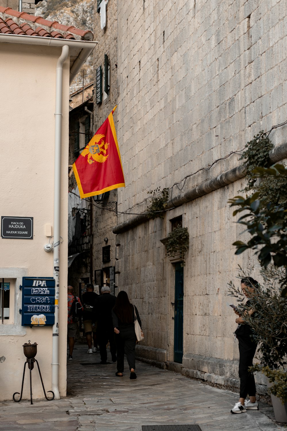 a red and yellow flag hanging from the side of a building