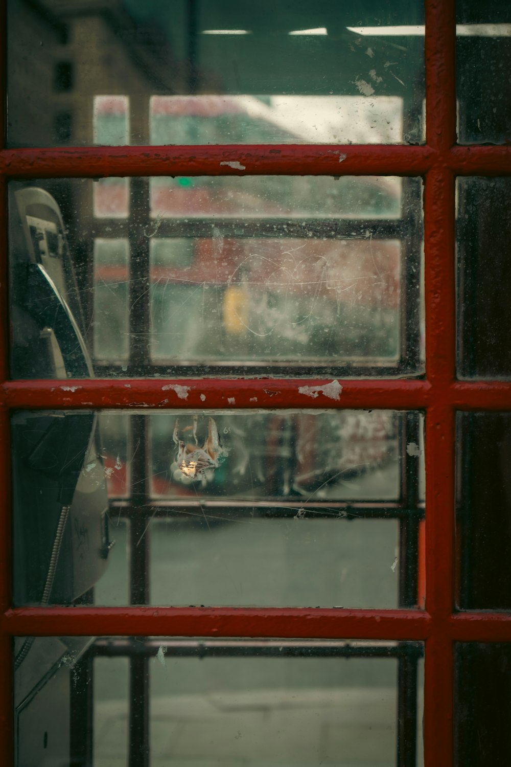 a red phone booth with a glass window