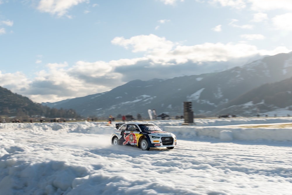 a rally car driving through the snow on a sunny day