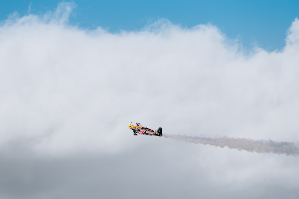 a plane flying in the sky with a trail of smoke coming out of it