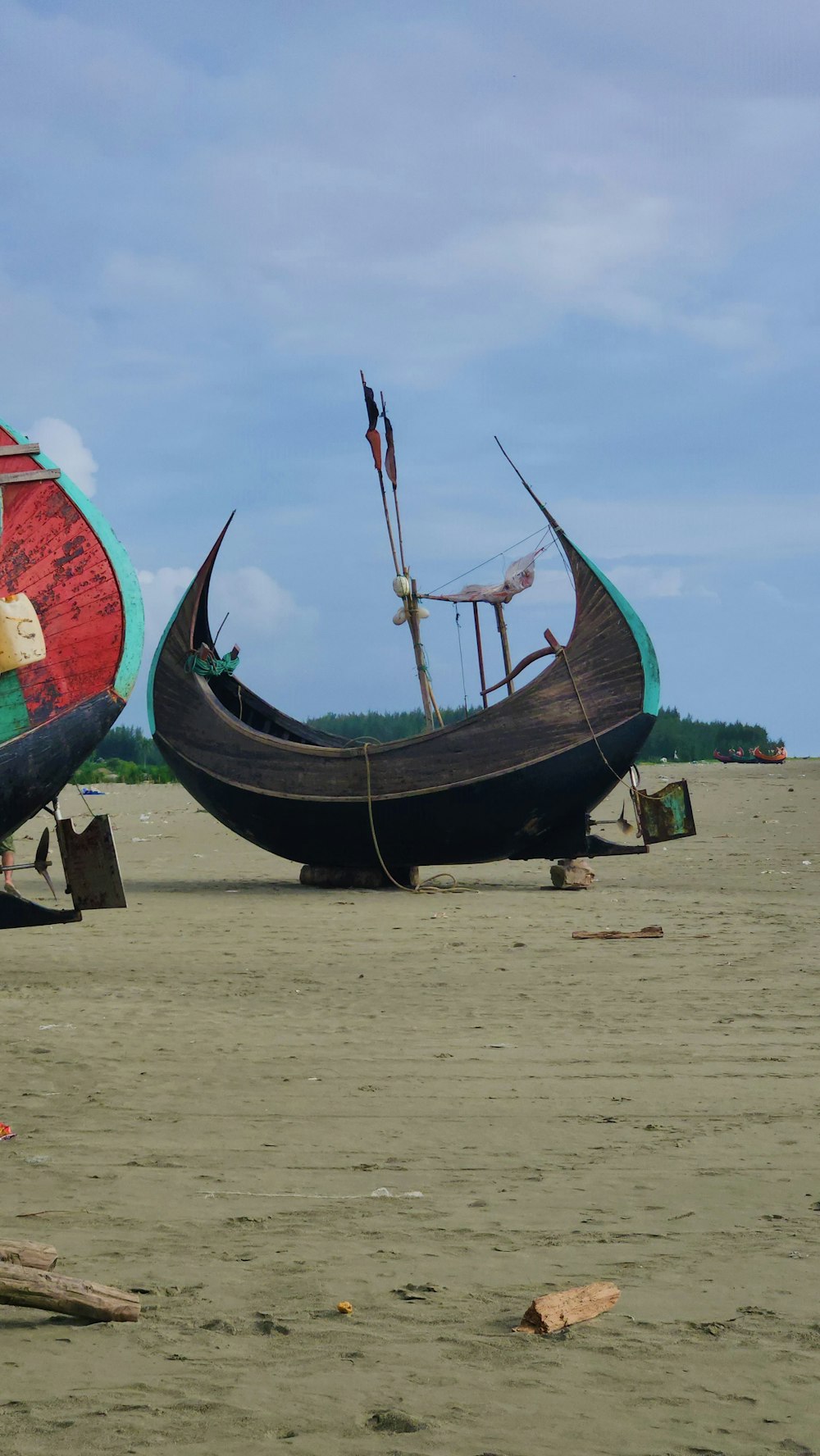 a couple of boats sitting on top of a sandy beach