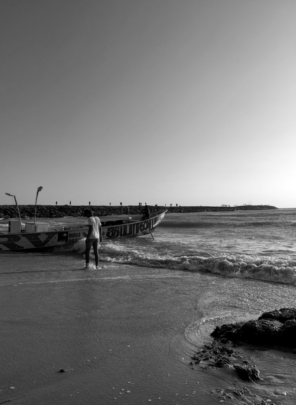 a man standing on a beach next to a boat