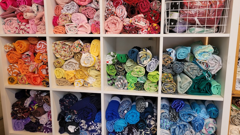 a shelf filled with lots of different colored scarves