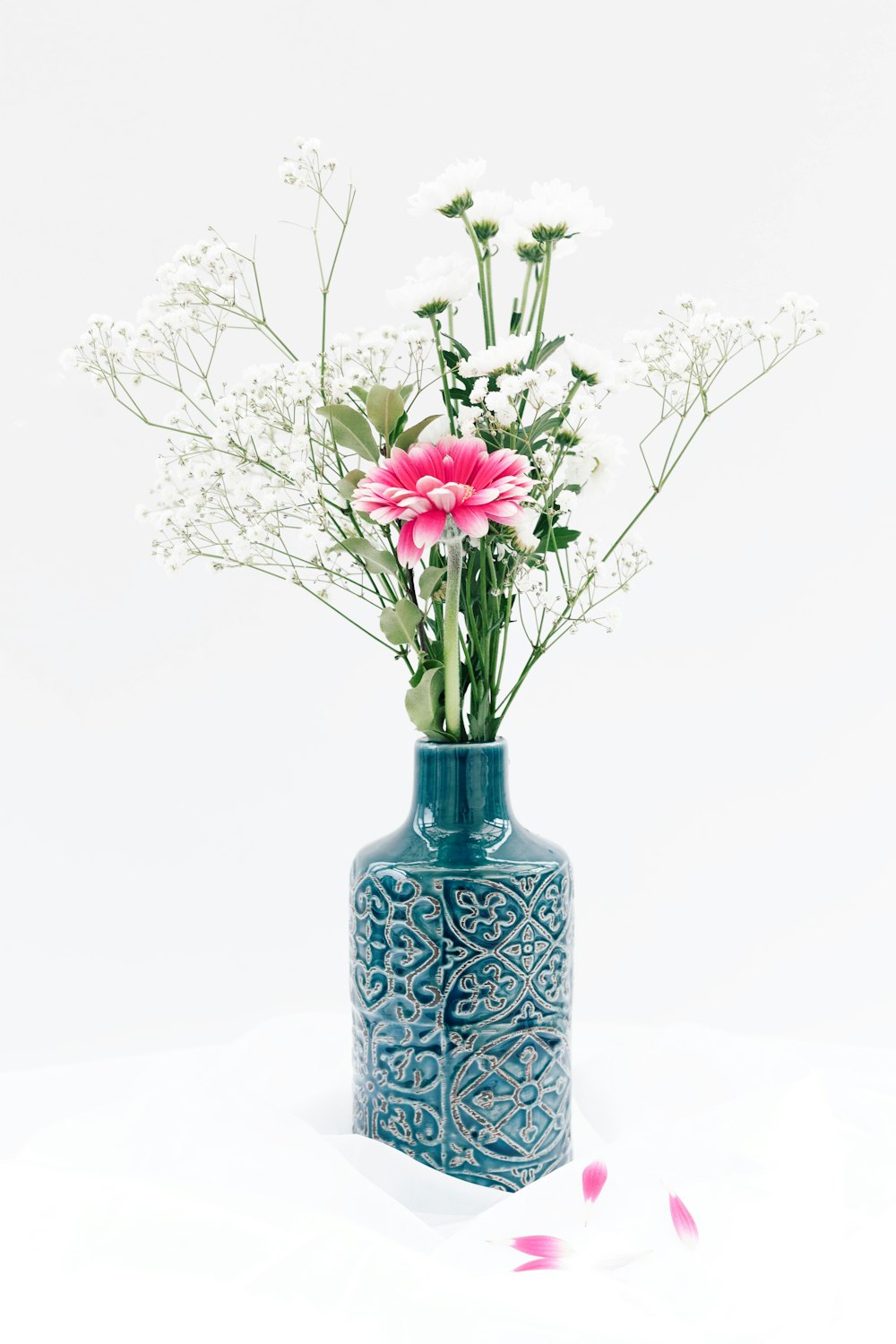 a blue vase with pink and white flowers in it