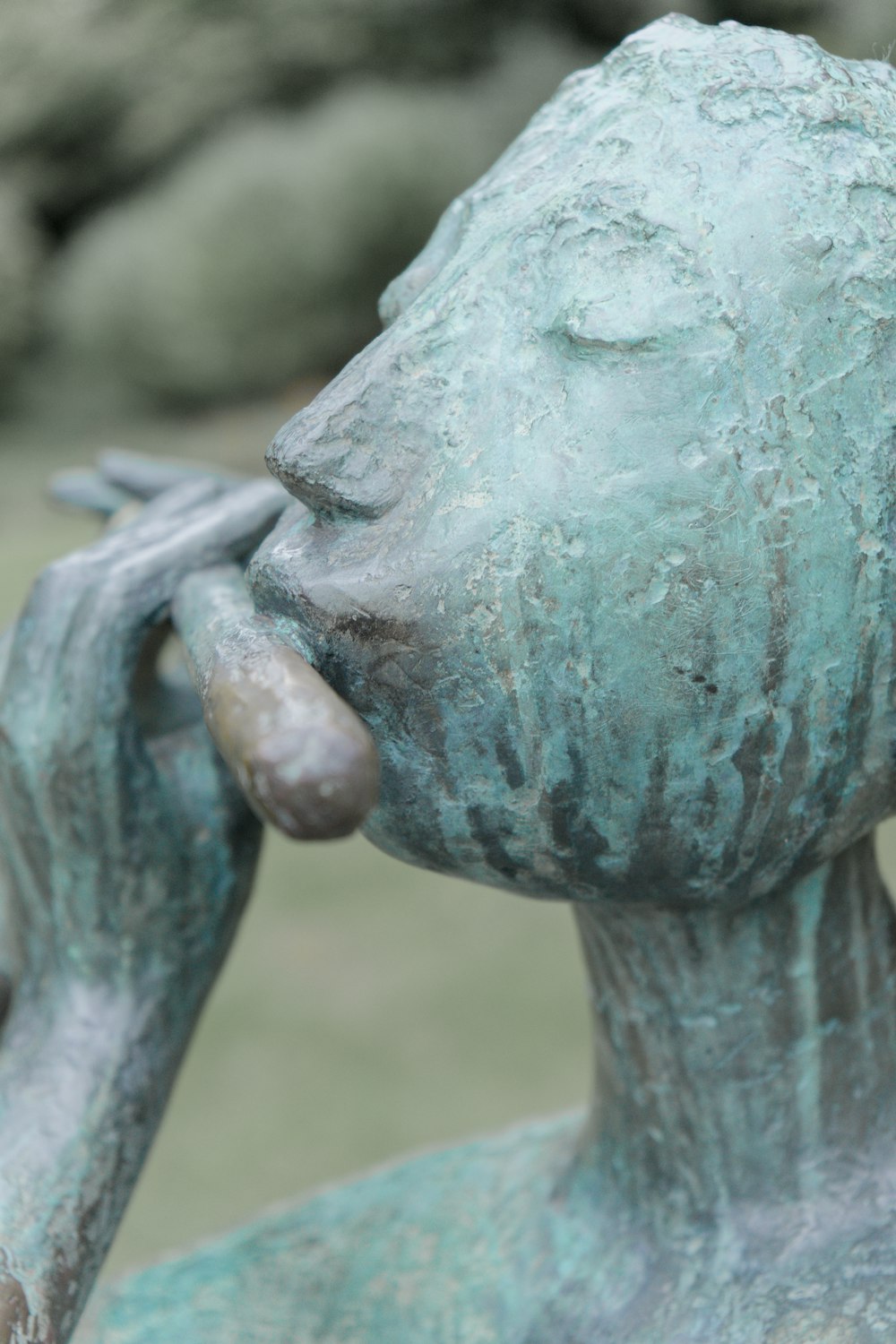 a close up of a statue of a person holding a bird