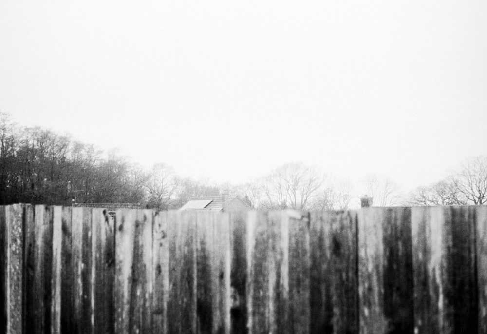 a black and white photo of a wooden fence