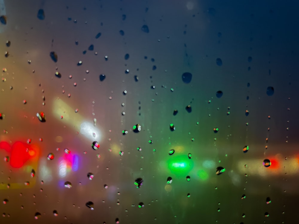 rain drops on a window with traffic lights in the background