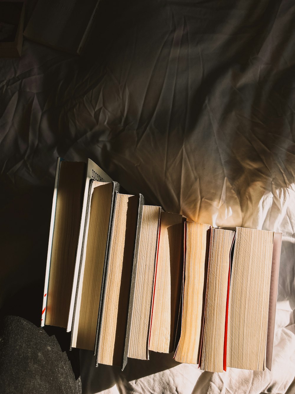 a row of books sitting on top of a bed