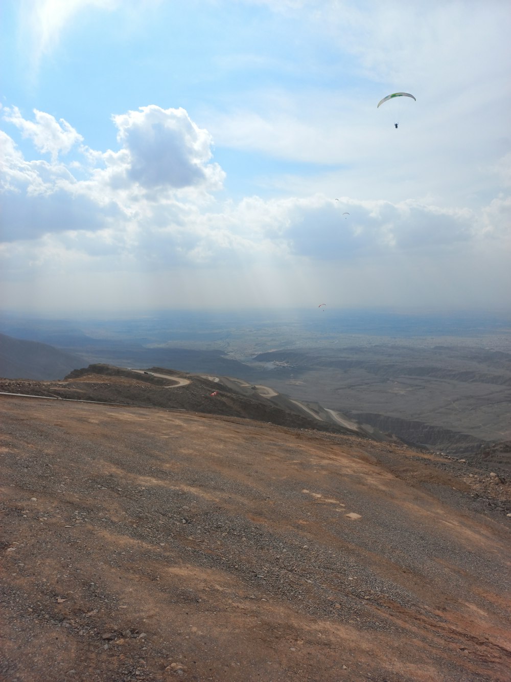 丘の上で凧を揚げる人