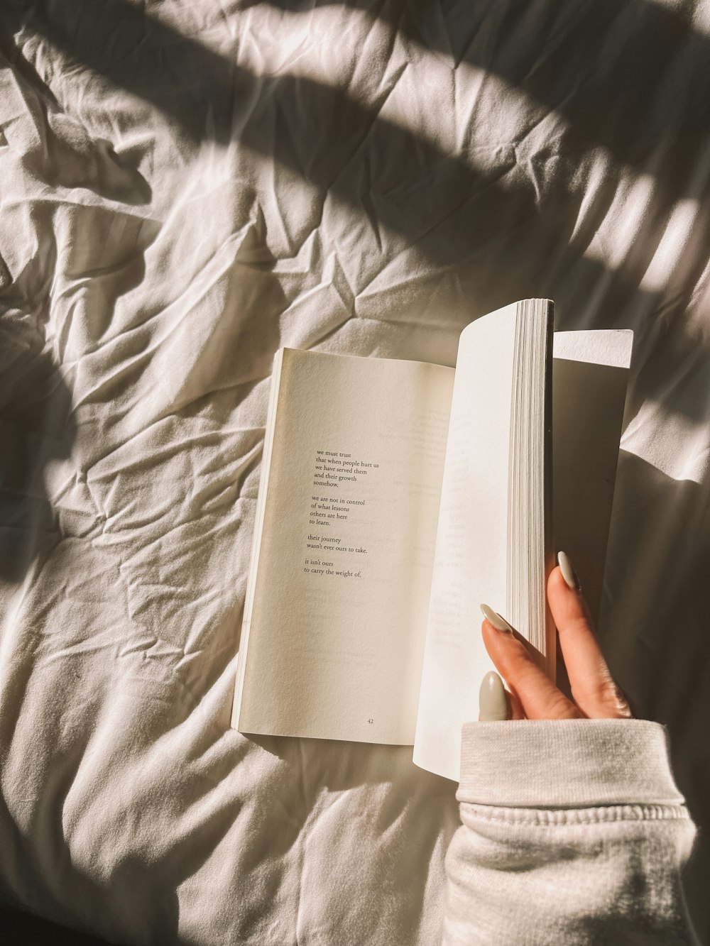 a person is reading a book on a bed