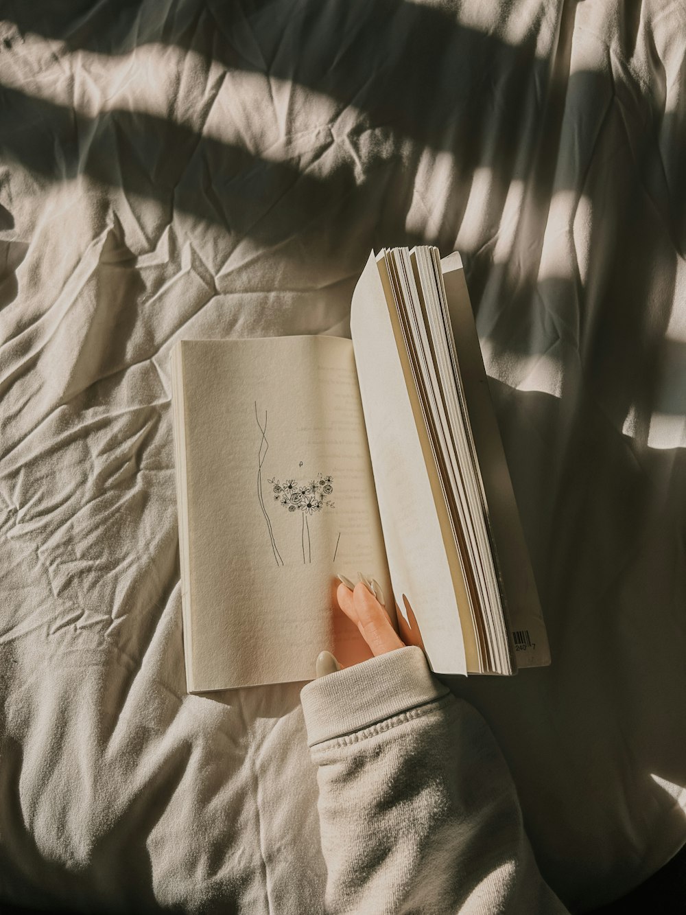 a person is reading a book on a bed