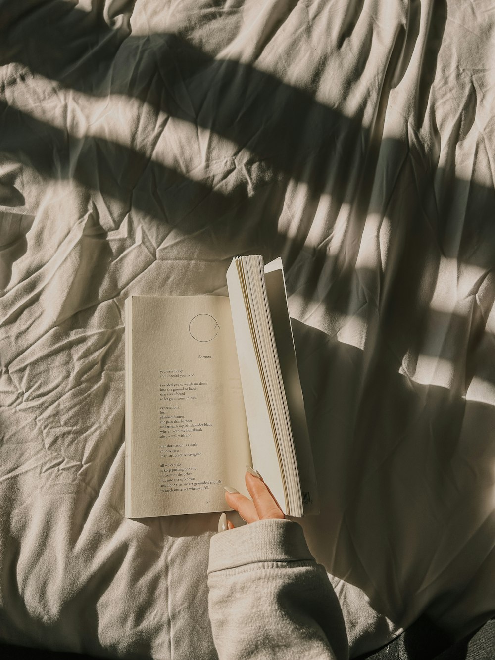 uma pessoa está lendo um livro em uma cama
