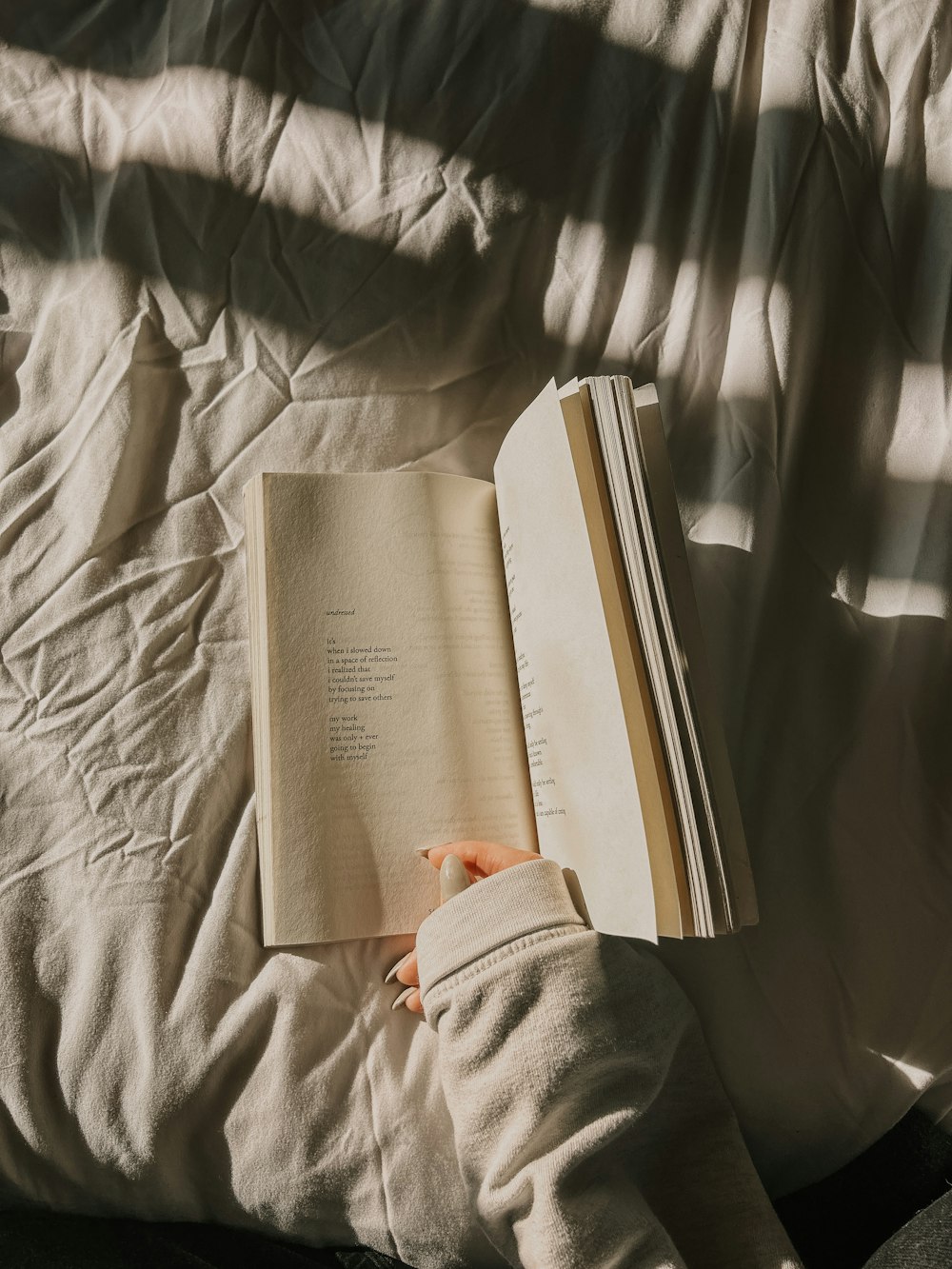 a person is reading a book on a bed