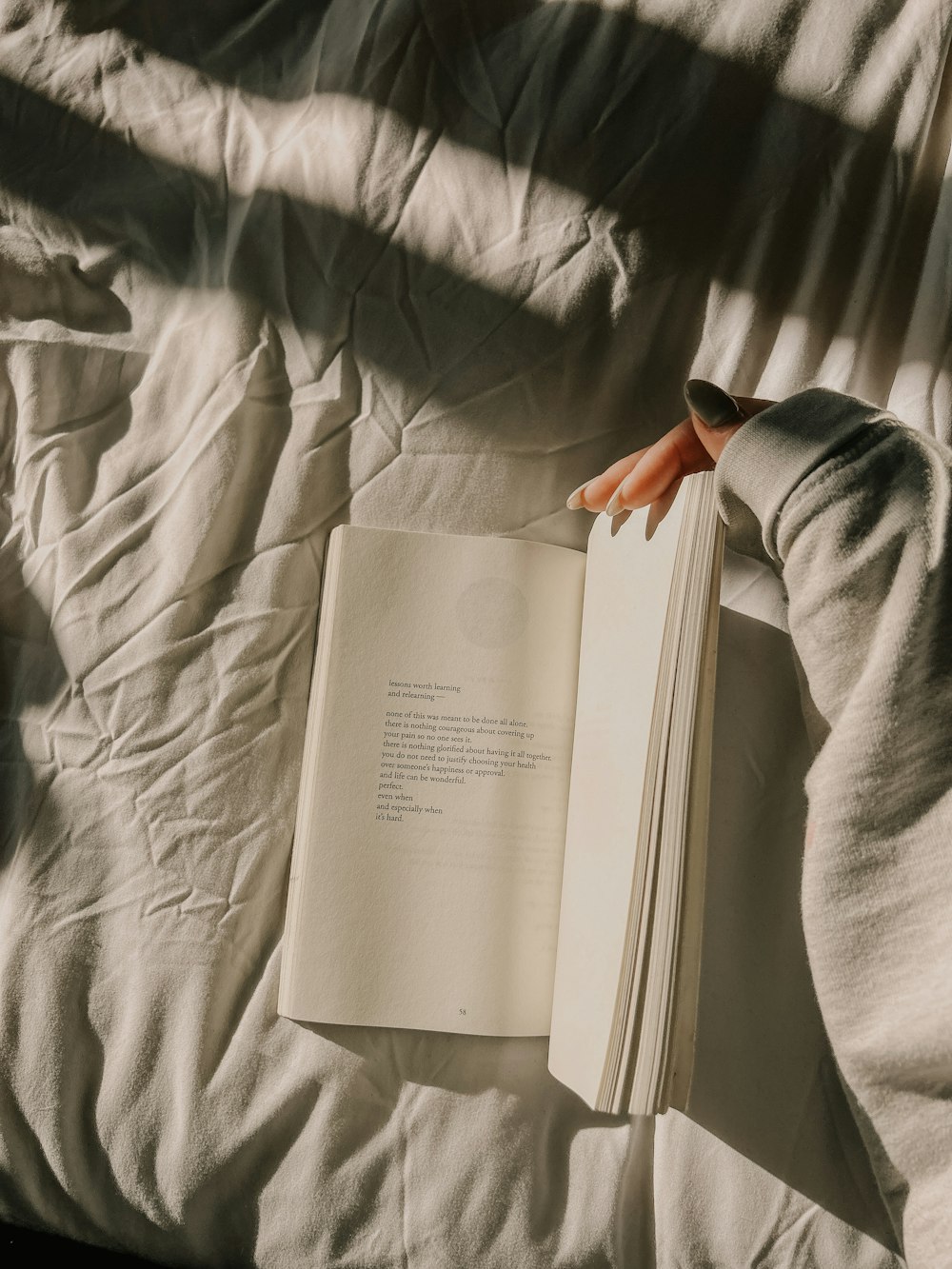 a person is reading a book on a bed