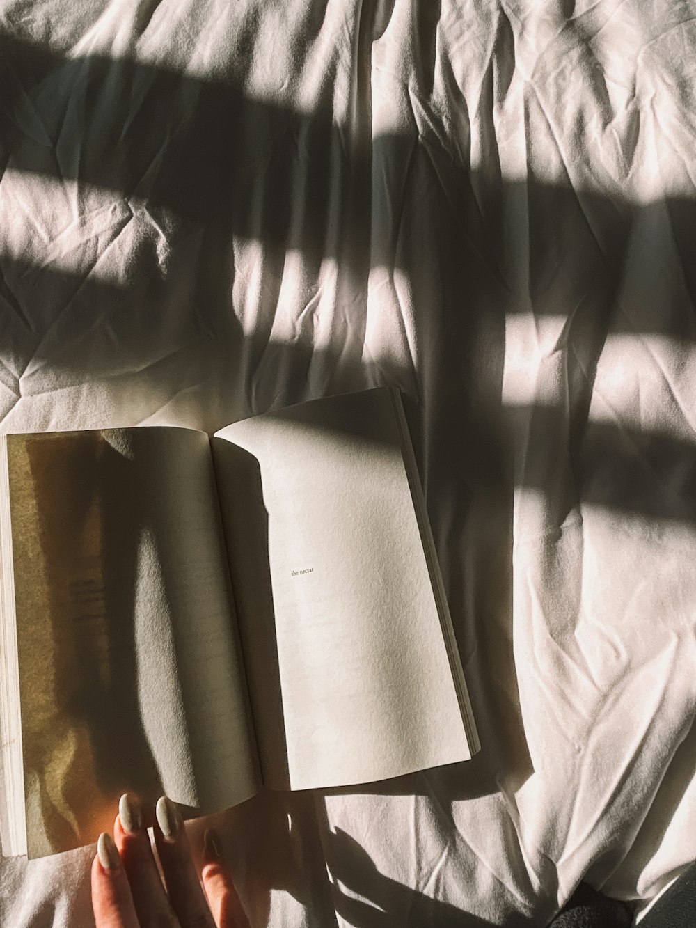 a person is reading a book on a bed