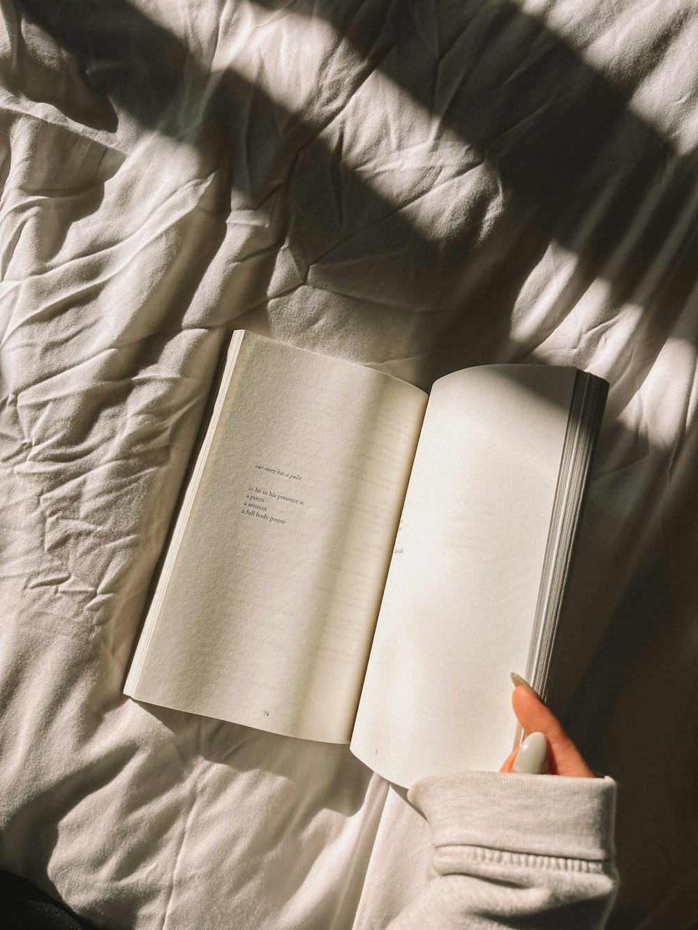 a person is reading a book on a bed