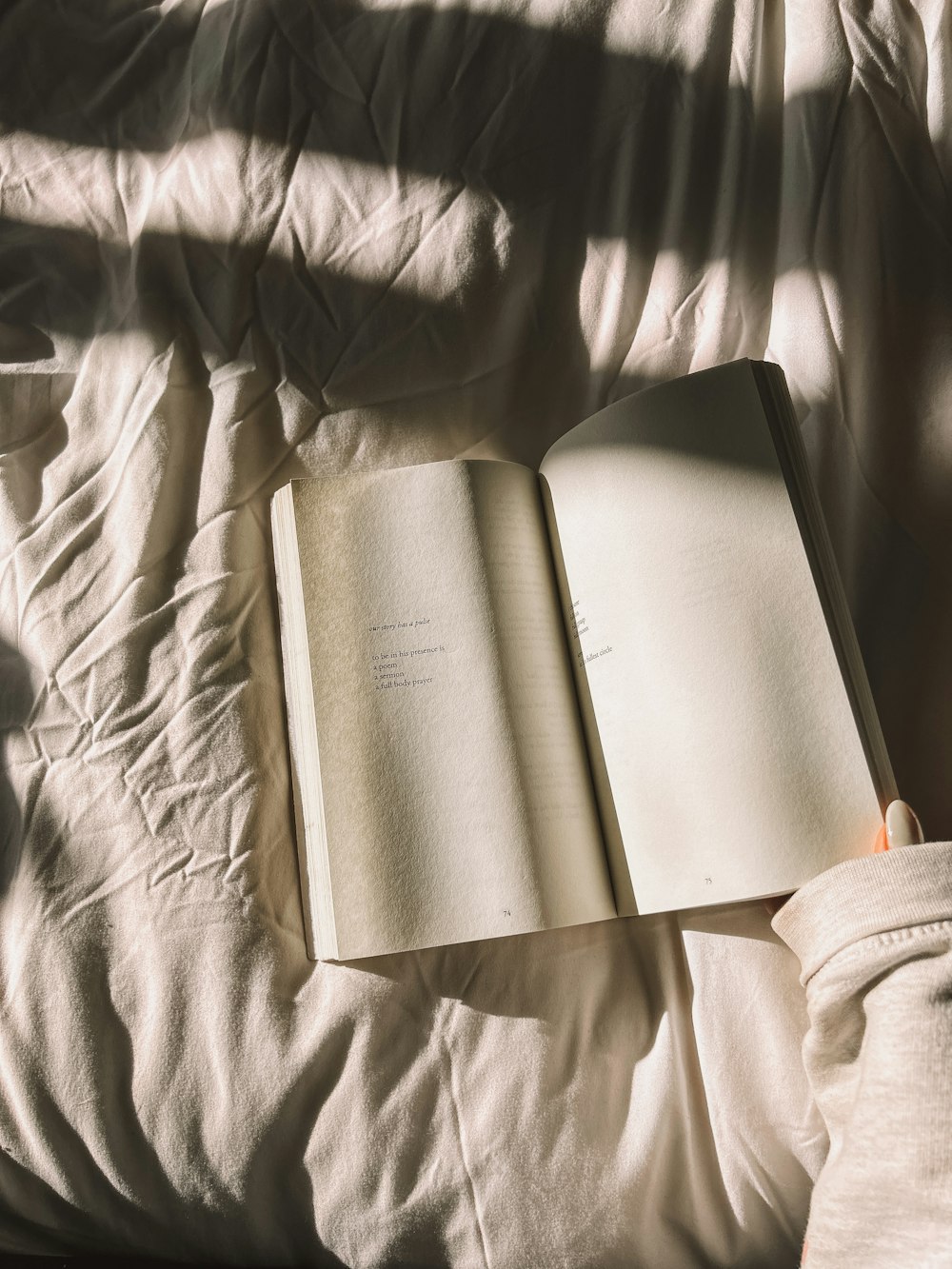 a person is reading a book on a bed