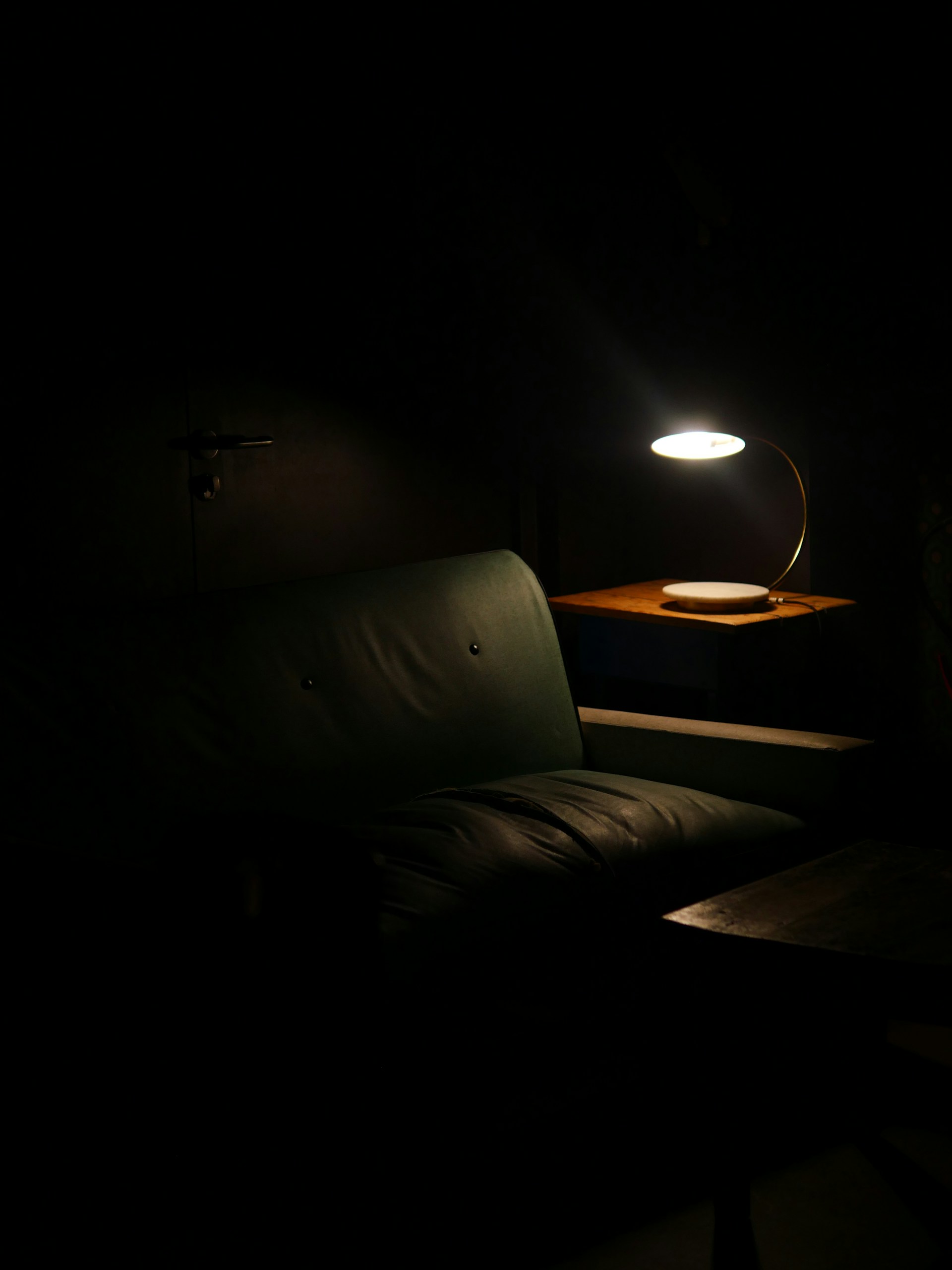 a couch in a dark room with a lamp on