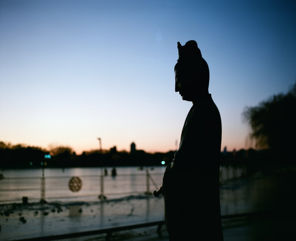 a man standing next to a body of water