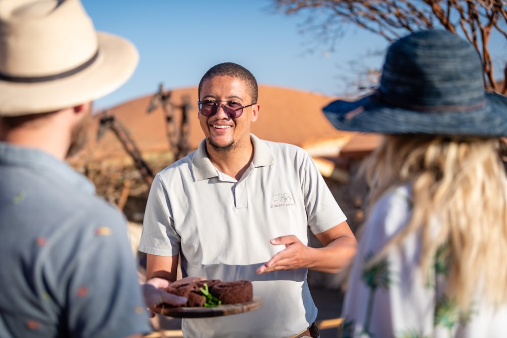 a man holding a plate of food with other people around him