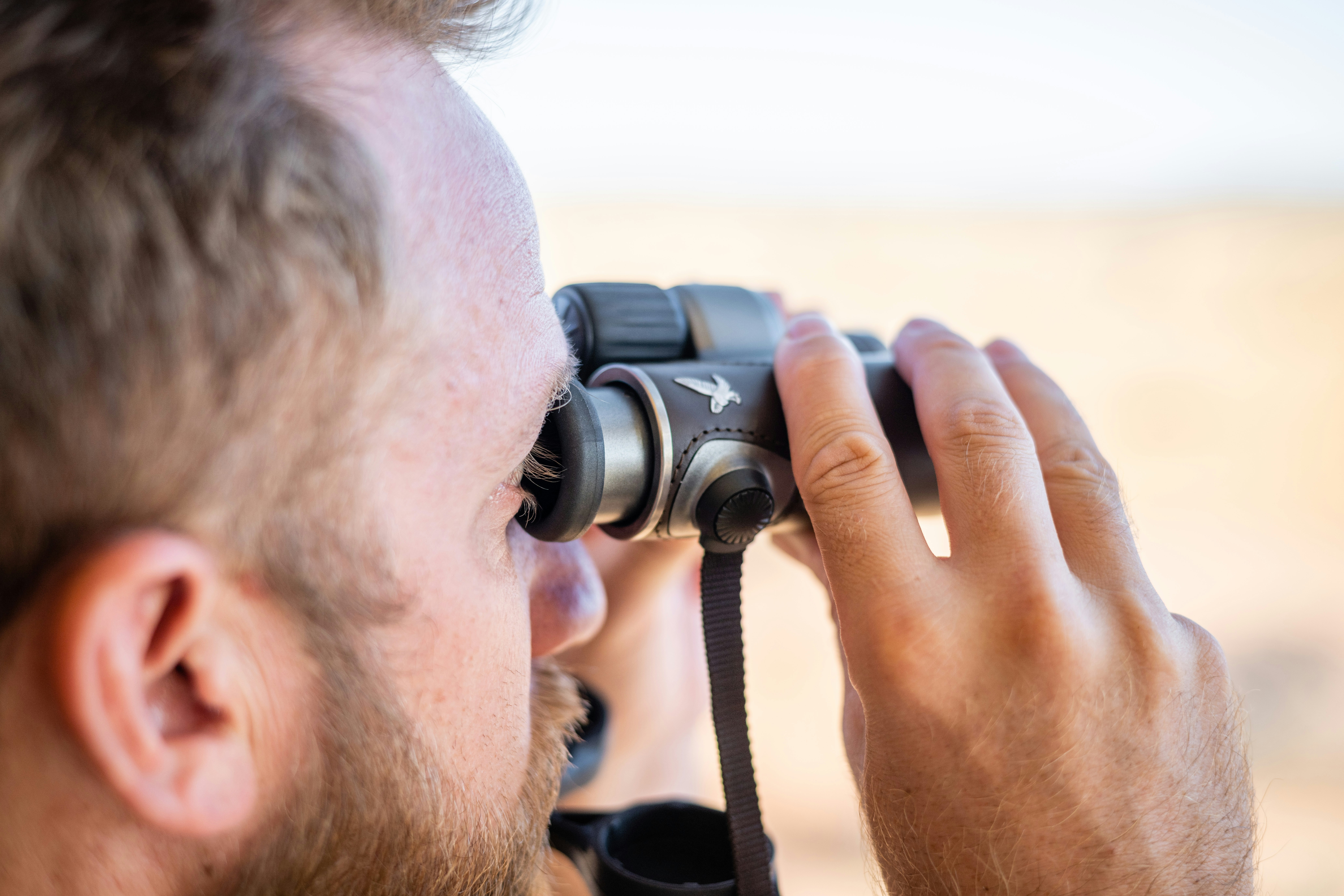 a man looking through a pair of binoculars